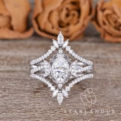 an engagement ring with diamonds on it and rose petals in the background, sitting on a wooden table