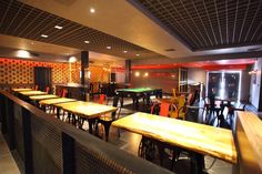 an empty restaurant with tables and stools in front of a pool table that looks like it has been turned into a bar