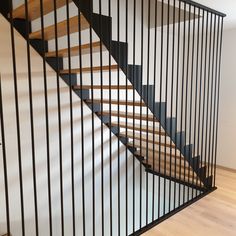 a black metal stair case with wooden handrails