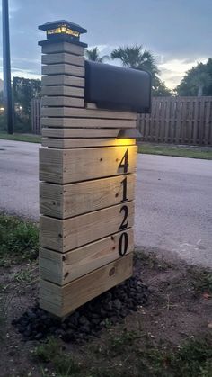 a mailbox made out of wooden pallets with the number 4 lit up on it