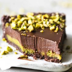 a piece of chocolate cake with pistachios on top