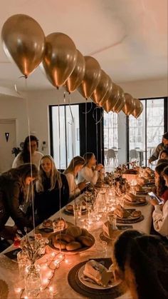 a group of people sitting around a table with plates and candles in front of them