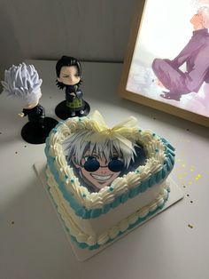 a cake with an anime character on it and two other figurines next to it