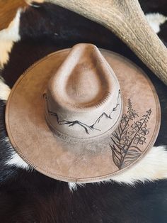 Vegan Suede Rancher Style Color- Light Brown Freehand burned hat Stiff brim 4" crown height 3.25" brim One size fits MOST (56cm-58) *All Sales Final Luxury Handmade Artisan Felt Hat, Mountain Burned Hat, Country Style Flat Crown Hat For Kentucky Derby, Artisan Style Brimmed Hats For Ranch, Rustic Curved Brim Hat For Kentucky Derby, Rustic Kentucky Derby Hat With Curved Brim, Artisan Flat Brim Hat For Ranch, Burned Hat Design Ideas, Felt Hat Burning Designs