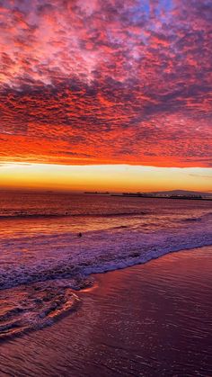 the sun is setting at the beach with waves coming in