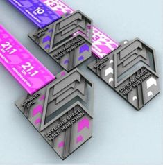 four medals are shown in three different colors and shapes, one is pink, the other is blue