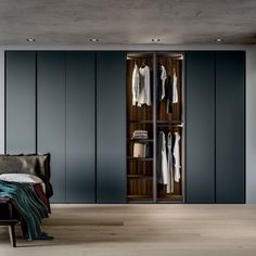 an open closet with clothes on hangers and a chair next to it in a bedroom