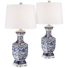 two blue and white vases with lamps on them