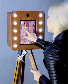 a woman is pointing at an electronic device with lights on it