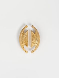 a gold plated brooch with an oval design on the front and back of it