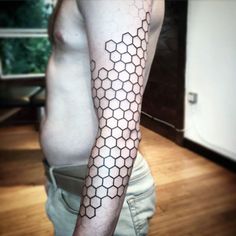 a man with a tattoo on his arm that has hexagons on it