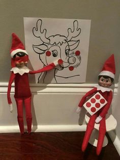 two elfs standing next to each other in front of a drawing on the wall