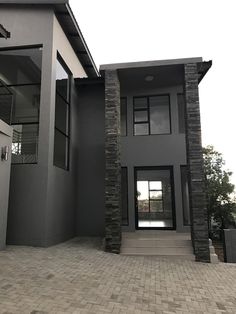 a grey house with black shutters and windows