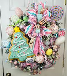 a wreath decorated with cookies, candies and other holiday decorations is hanging on the front door