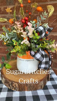 a vase filled with flowers sitting on top of a wooden table next to a black and white checkered table cloth