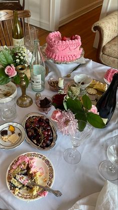 a table topped with lots of different types of food and desserts next to bottles of wine