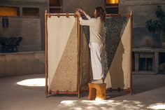 a person standing in front of a large piece of art with one hand on the wall