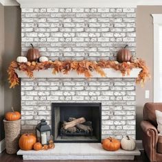 a living room filled with furniture and a fire place covered in pumpkins on the mantle