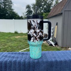 a blue and black coffee cup sitting on top of a towel