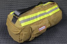 a firefighter's duffel bag sitting on the floor with no one around it