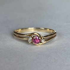 10K Gold Ruby and Natural Diamond Accent Ring, Size 7.75, 1.56 grams Beautiful Ring with Ruby center stone. One accent diamond stone is missing!  Size: 7.75 Weight: 1.56grams Main Stone: Ruby Color: Berry Pink Size: ca. 3mm dia. Secondary Stone: Natural Diamonds, 1.7mm dia. Marking: 10KP Gold: Yellow Gold Bandwidth: 2mm  Tested: Presidium Gemtester ll, Diamond Selector ll,  Olympus/Evident Scientific Vanta GX Precious Metals XRF Analyzer. Condition: Good preowned, 1 missing Diamond - Refer to pi Ring With Ruby, Unique Gold Jewelry Designs, Pink Stone Rings, Diamond Accent Ring, Gold Bride Jewelry, Gold Rings Fashion, Gold Ring Designs, Bride Jewellery, Gold Jewellery Design