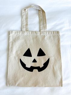 a white bag with a black jack - o'- lantern face on it