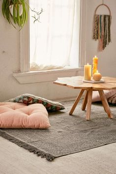 a living room filled with furniture next to a table and a potted plant on top of a window sill