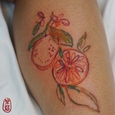 a tattoo on the leg of a woman with oranges