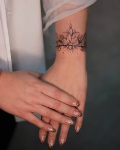 a woman's wrist with a flower tattoo on it