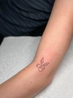 a woman's arm with a small tattoo on it