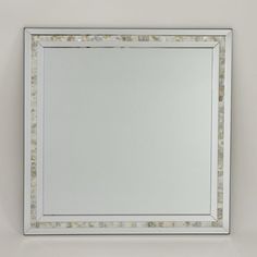 a white framed mirror sitting on top of a wall