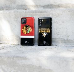 two cell phones that are sitting on the ground next to each other, one has a hockey jersey on it