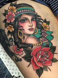 a woman's thigh with tattoos on it and flowers around her waist, as well as a rose