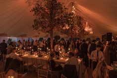 a group of people sitting at tables in a tent