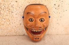 This is an authentic vintage Japanese wooden mask from the mid-late 1900's, featuring the historic male face with a wide mustache, bared, teeth, and dark eye whites. The Mikazuki mask is worn in Japanese Noh theater to depict vengeful spirits in need of appeasement. 5 1/2"W x 3"D X 8 1/4"H Noh Theatre, Wooden Mask, Appeasement, Dark Eyes, Male Face, Vintage Japanese, Labour Day, 3 D, Light Pink