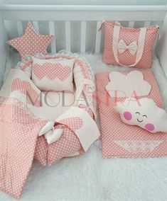 a baby crib with pink and white polka dot bedding, teddy bear pillow, blanket and bumper