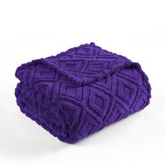 a purple blanket sitting on top of a white floor