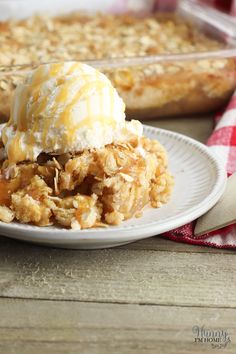 a white plate topped with an ice cream covered dessert next to a casserole dish