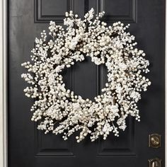 a black door with a white wreath on it