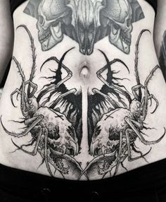 a woman's stomach with tattoos on it and two skulls in the middle,