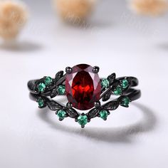 a ring with a red stone surrounded by green stones