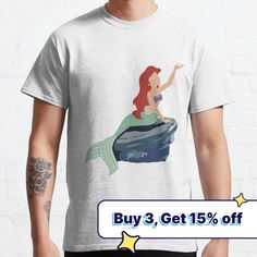 the little mermaid is sitting on top of a rock and pointing at something with her hand