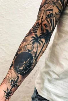 a man's arm with a clock, compass and palm trees tattoo on it