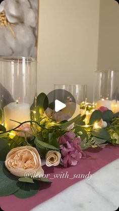 flowers and candles are sitting on a table