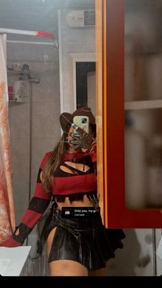 a woman in a costume is looking into a mirror