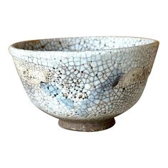 A Japanese ceramic Chawan (tea bowl) of e-Shino (painted Shino) ware style circa mid-late 18th century Edo period. The classically shaped bowl features an abstract blue paint of blue grass and displays strong characters in the milky white glaze, with overall crawling and crackling effect. One of the most distinctive characteristics of Shino that is exemplified on this bowl is the small pinholes called suana, which tea masters favor (termed as yuzuhada, or citron skin). The milky-white feldspar g