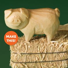 a wooden pig on top of hay with an orange button that says make this in front of it