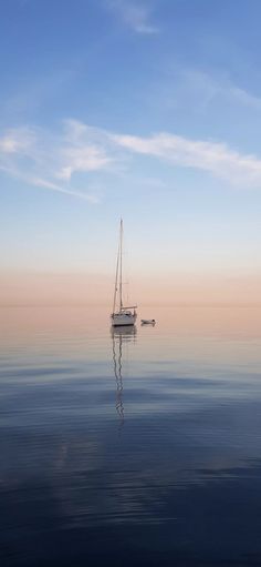 a sailboat floating in the ocean at sunset