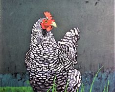 a painting of a chicken on the side of a building with grass in front of it