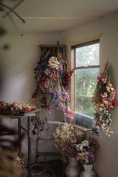 flowers are hanging from the ceiling in front of a window